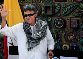 Jesus Santrich, member of the Revolutionary Armed Forces of Colombia (FARC), waves to journalists after a press conference on the sidelines of peace talks with with Colombia's government in Havana, Cuba, Thursday, March 21, 2013. Colombia's government and largest guerrilla army have closed another round of peace talks without reaching a deal on agrarian reform, the first of six agenda points for negotiations taking place in Havana. (AP Photo/Franklin Reyes)