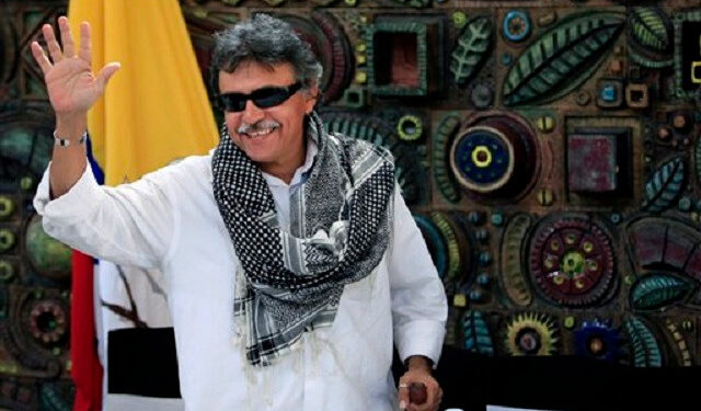 Jesus Santrich, member of the Revolutionary Armed Forces of Colombia (FARC), waves to journalists after a press conference on the sidelines of peace talks with with Colombia's government in Havana, Cuba, Thursday, March 21, 2013. Colombia's government and largest guerrilla army have closed another round of peace talks without reaching a deal on agrarian reform, the first of six agenda points for negotiations taking place in Havana. (AP Photo/Franklin Reyes)