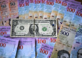 This ilustration shows Venezuelan Bolivar banknotes and a US one-dollar bill in Caracas on January 28, 2019. - Venezuela devalued its currency by almost 35 percent on Monday to bring it into line with the exchange rate of the dollar on the black market. The exchange rate is now fixed at 3,200 bolivars to the dollar, almost matching the 3,118.62 offered on the dolartoday.com site that acts as the reference for the black market. (Photo by YURI CORTEZ / AFP)