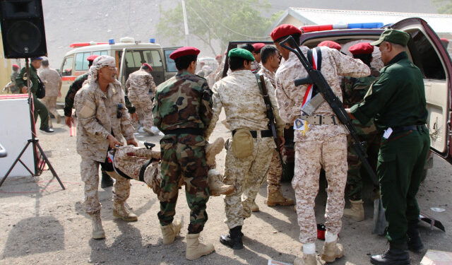 Soldiers carry the injured following a missile attack on a military parade during a graduation ceremony for newly recruited troopers in Aden, Yemen August 1, 2019. REUTERS/Fawaz Salman