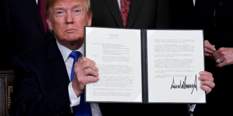 U.S. President Donald Trump holds his signed memorandum on intellectual property tariffs on high-tech goods from China, at the White House in Washington, U.S. March 22, 2018.  REUTERS/Jonathan Ernst
