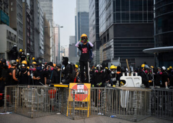 Protesters face off with riot police at Kowloon Bay in Hong Kong on August 24, 2019, in the latest opposition to a planned extradition law that has since morphed into a wider call for democratic rights in the semi-autonomous city. - Hong Kong riot police on August 24 fired tear gas and baton-charged protesters who retaliated with a barrage of stones, bottles and bamboo poles, as a standoff in a working-class district descended into violence. (Photo by Lillian SUWANRUMPHA / AFP)