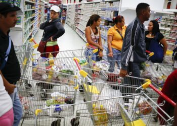 Customers line up to pay for their purchases at a state-run Bicentenario supermarket in Caracas May 2, 2014.  President Nicolas Maduro is introducing a controversial shopping card intended to combat Venezuela's food shortages but decried by critics as a Cuban-style policy illustrating the failure of his socialist policies. Maduro, the 51-year-old successor to Hugo Chavez, trumpets the new "Secure Food Supply" card, which will set limits on purchases, as a way to stop unscrupulous shoppers stocking up on subsidized groceries and reselling them. REUTERS/Jorge Silva (VENEZUELA - Tags: POLITICS BUSINESS SOCIETY)