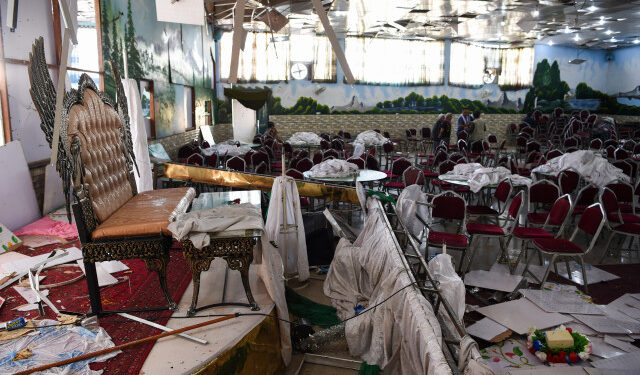 Afghan men investigate in a wedding hall after a deadly bomb blast in Kabul on August 18, 2019. - More than 60 people were killed and scores wounded in an explosion targeting a wedding in the Afghan capital, authorities said on August 18, the deadliest attack in Kabul in recent months. (Photo by Wakil KOHSAR / AFP)