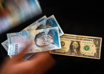 A man counts Venezuelan bolivar banknotes next to a US one-dollar bill in Caracas on August 2, 2018.
Venezuela's government on Thursday loosened the tight currency controls it first put in place 15 years ago, with the pro-government Constituent Assembly announcing the passage of a decree authorizing money exchange operations. / AFP PHOTO / Federico PARRA