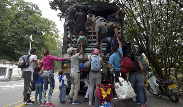 Venezuelan migrants climb on a truck on the road from Cucuta to Pamplona, in Norte de Santander Department, Colombia, on February 10, 2019. - Opposition leader Juan Guaido, recognized by some 50 countries as Venezuela's interim president, warned the military Sunday that blocking humanitarian aid from entering the country is a "crime against humanity." (Photo by Raul ARBOLEDA / AFP)