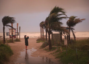 COCOA BEACH, FLORIDA - SEPTEMBER 02: A woman takes a picture as the effects of Hurricane Dorian begin to be felt on September 2, 2019 in Cocoa Beach, Florida. Dorian, once expected to make landfall near Cocoa Beach as a category 4 storm, is currently predicted to turn north and stay off the Florida coast, lessening the impact on the area.   Scott Olson/Getty Images/AFP