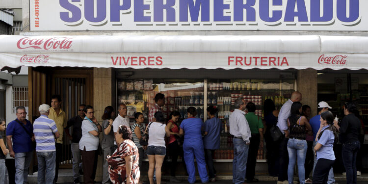 People line up to buy basic products outside a supermarket in Caracas, Venezuela January 15, 2016. Venezuelan President Nicolas Maduro's socialist government decreed on Friday a 60-day "economic emergency" for the recession-hit OPEC nation reeling from low oil prices and a sputtering state-led economic model. REUTERS/Marco Bello
