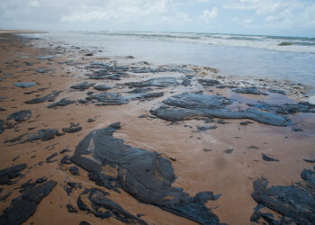 Handout picture released by the Sergipe State Environment Administration (Ademas) on September 25, 2019, showing oil spilled on a beach in Pirambu, Sergipe state, Brazil. - Brazil's President Jair Bolsonaro said on October 7 that the mysterious oil stains that appeared on 132 beaches in northeastern Brazil haver their origin in another country, wihtout mention which one. (Photo by HO / ADEMAS / AFP) / RESTRICTED TO EDITORIAL USE - MANDATORY CREDIT "AFP PHOTO / ADEMAS / Marcos Rodrigues" - NO MARKETING - NO ADVERTISING CAMPAIGNS - DISTRIBUTED AS A SERVICE TO CLIENTS