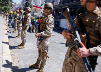 Chilean army soldiers stand guard outside a burned down Supermarket after a protest in Valparaiso, Chile, on October 20, 2019. - Chile was at a standstill on Sunday following two days of violent protests sparked by anger over economic conditions and social inequality that left three people dead, killed in the torching of a Santiago supermarket. (Photo by JAVIER TORRES / AFP)