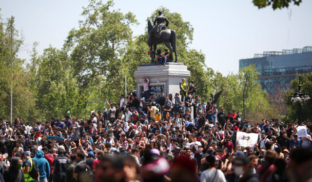 People prostest at Plaza Italia square in Santiago, Chile, on October 21, 2019. - Chile's death toll has risen to 11, authorities said on Monday, after three days of violent demonstrations and looting that saw President Sebastian Pinera claim the country was "at war." (Photo by Pablo VERA / AFP)