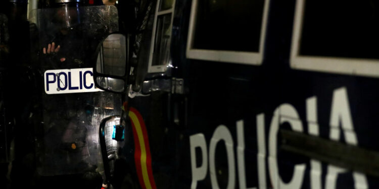 Policías de pie junto a un coche de policía mientras los manifestantes independentistas asisten a una protesta contra la acción policial frente a la sede de la Policía Nacional, en Barcelona, España, el 26 de octubre de 2019. REUTERS/Sergio Pérez