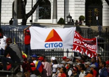 Un partidario oficial del gobierno sostiene una pancarta que muestra el logotipo de Citgo Petroleum, la refinería estadounidense controlada por Petróleos de Venezuela SA (PDVSA), durante un mitin en Caracas, Venezuela, el 31 de enero de 2019. Fotógrafo: Marco Bello / Bloomberg.
