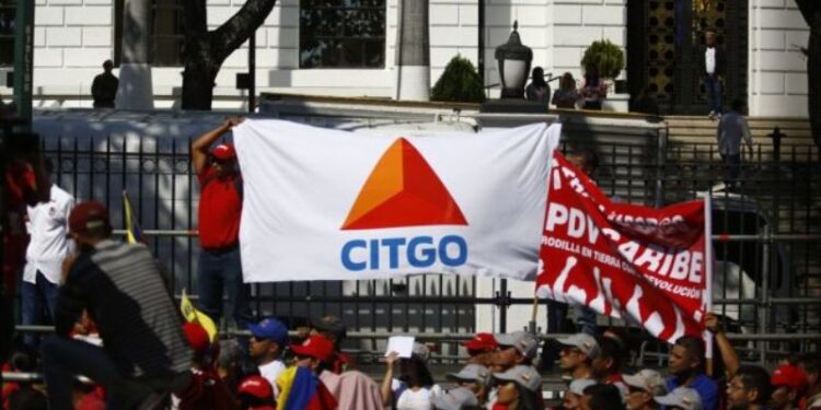 Un partidario oficial del gobierno sostiene una pancarta que muestra el logotipo de Citgo Petroleum, la refinería estadounidense controlada por Petróleos de Venezuela SA (PDVSA), durante un mitin en Caracas, Venezuela, el 31 de enero de 2019. Fotógrafo: Marco Bello / Bloomberg.