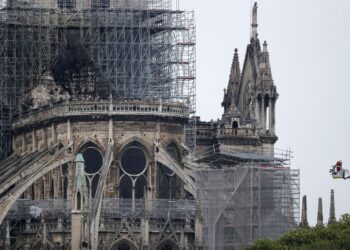EPA9577. PARIS (FRANCIA), 16/04/2019.- Un bombero trabaja subido en un elevador cerca de la parte de la estructura la catedral de Notre Dame destruida, este martes en París (Francia). Francia evalúa los daños sufridos por la catedral de Notre Dame de París, devastada por un incendio cuyo origen es todavía desconocido y está siendo investigado por la Justicia. EFE/ Ian Langsdon