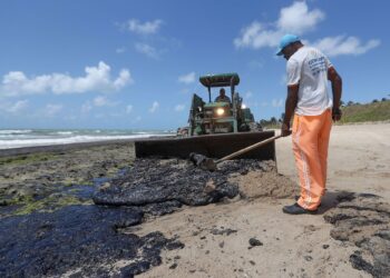 Trabajadores intentan contener y limpiar las manchas de petróleo que contaminan la playa Lagoa do Pau, en el municipio de Coruripe, estado Alagoas. EFE/ Carlos Ezequiel Vannoni