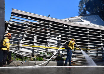 Firefighters work outside a destroyed home along North Tigertail Road near The Getty Center in Los Angeles, California on October 29, 2019. - More than 1,000 firefighters battled a wind-driven blaze Monday that broke out near the renowned Getty Center in Los Angeles, prompting widespread evacuations as the flames destroyed several homes and forced the shutdown of schools and roads. The so-called Getty Fire ignited overnight near a major freeway and quickly spread south and west towards neighborhoods, scorching some 600 acres (240 hectares) and sending people fleeing in the dark. (Photo by Frederic J. BROWN / AFP)