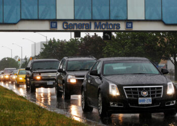 FILE PHOTO: A line up of cars is seen on a road after a shift change at the General Motors Car assembly plant in Oshawa, June 1, 2012.   REUTERS/Mark Blinch/File Photo