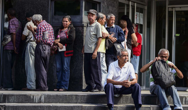 Elderly people wait for their pension monthly payment outside a bank in Caracas, on February 22, 2019. (Photo by RONALDO SCHEMIDT / AFP)