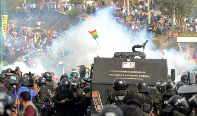 Bolivian riot police clash with supporters of Bolivia's ex-President Evo Morales during a protest against the interim government, in Sacaba, Chapare province, Cochabamba department on November 15, 2019. - Bolivia's interim president Jeanine Anez said Friday that exiled ex-president Evo Morales would have to "answer to justice" over election irregularities and government corruption if he returns. (Photo by STR / AFP)