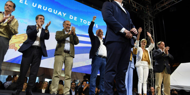The presidential candidate for Uruguay's Partido Nacional party, Luis Lacalle, addresses supporters, alongside coalition members, following the results in the run-off election, in Montevideo on November 24, 2019. - Uruguay's Electoral Court said Sunday's presidential election is too close to call and the result would not be known for several days pending a recount. The announcement came after a night of drama in Montevideo when unofficial results showed center-right candidate Luis Lacalle Pou only around 30,000 votes ahead of the ruling party's Daniel Martinez. (Photo by PABLO PORCIUNCULA / AFP)