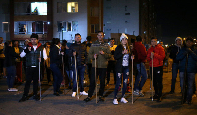 Residents hold sticks as they stand in front of their apartment block to guard their homes from possible looting after a curfew was enforced following renewed protests on the second day of a national strike, in Bogota, Colombia, November 22, 2019. REUTERS/Luisa Gonzalez