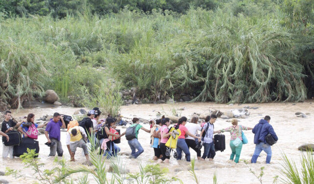 People cross from San Antonio del Tachira in Venezuela to Cucuta in Colombia through "trochas" -illegal trails- near the Simon Bolivar international bridge, on November 20, 2019, after the Colombian government ordered the border closure ahead of the upcoming national strike next November 21. (Photo by Schneyder MENDOZA / AFP)