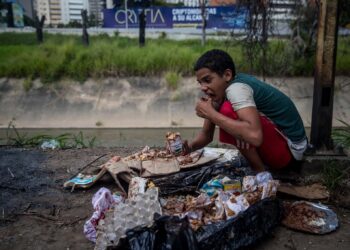 ACOMPAÑA CRÓNICA: VENEZUELA CRISIS. CAR01. CARACAS (VENEZUELA), 21/12/2018.- Jesús, de 16 años, come algo que encontró en una bolsa de basura el pasado 10 de noviembre de 2018, en el barrio Las Mercedes de Caracas (Venezuela). Las calles de Caracas están llenas de niños que corren, se ríen, se bañan en ríos sucios, buscan comida en la basura y también consumen drogas, son menores de edad abandonados que muestran una de las tantas caras de la severa crisis económica y social que azota al país petrolero que es Venezuela. EFE/Miguel Gutiérrez