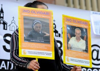 A woman holds posters of people accused of sexual abuse, corruption of children and mistreatment during a demonstration outside court where the veredict in a sexual abuse case against two priests and a gardener at the Provolo Institute in Mendoza is expected, in this Argentine city, on November 25, 2019. - Priests Nicola Corradi, an 83-year-old Italian, and 59-year-old Argentine Horacio Corbacho, as well as former gardener Armando Gomez, 49, are accused of sexual abuse, corruption of children and mistreatment at a Catholic school for deaf children, for which they could face up to 50 years in jail. (Photo by Andres Larrovere / AFP)