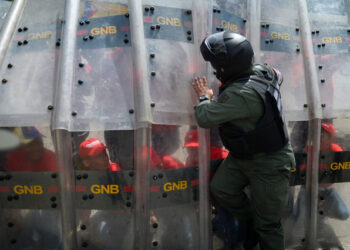 A member of the National Guard teaches deffensive tactics to civilians during military exercises to activate the integral defense entities of Miranda State, in the framework of Operation Sovereignty and Peace 2019, at the National Guard School "Ramo Verde" in Caracas, Venezuela, on September 16, 2019. - During the operation, civil forces and the Bolivarian militia learn about military tactics from the Bolivarian National Guard in order to have a rapid response in case of protests or a foreign military intervention in Venezuela. (Photo by Matias Delacroix / AFP)