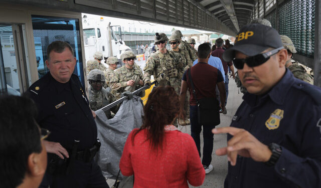 HIDALGO, TX - NOVEMBER 02: U.S. Customs and Border Protection officers and U.S. Army troops allow people to pass over the international bridge with Mexico to an immigration checkpoint on November 2, 2018 in Hidalgo, Texas. U.S. President Donald Trump ordered the troops to the border to bolster security at points where an immigrant caravan may attempt to cross in upcoming weeks.   John Moore/Getty Images/AFP