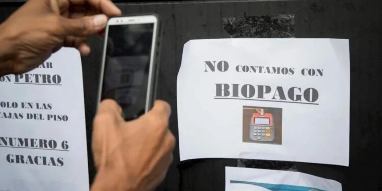 Caracas (Venezuela), 28/12/2019.- Un hombre fotografía un anuncio que dice «no contamos con Biopago» una herramienta utilizada para realizar transacciones en Petro, este sabado, en Caracas (Venezuela). EFE/ Rayner Peña R.