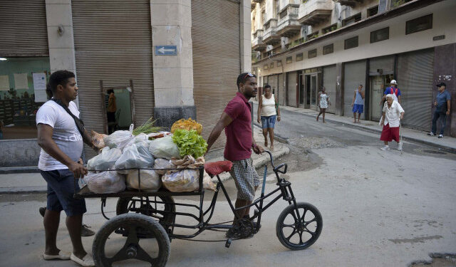 Cubans transport vegetables and fruits on a tricycle along a street in old Havana, on April 4, 2019. - A drastic reduction in the circulation of Cuban state newspapers this week, awaken the spectre of the 90s crisis, amid the shortage of basic goods, the bad news from Venezuela and the tightening of the US blockade. (Photo by YAMIL LAGE / AFP)