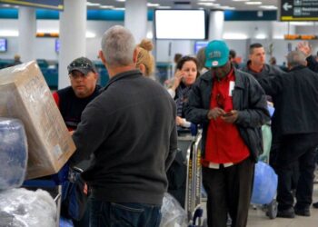 La gente espera en la fila con el equipaje envuelto en plástico antes de registrarse en un vuelo chárter de Havana Air a Cuba. NICK SWYTER MIAMI HERALD STAFF