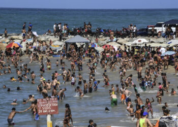 People enjoy Bahia de los Ninos beach in La Guaira, Vargas state, Venezuela, on January 12, 2020. - With rum, reggaeton and "no change" on the horizon, Venezuelans go to the beach after a week of protests and disputes in the National Assembly. (Photo by Yuri CORTEZ / AFP)