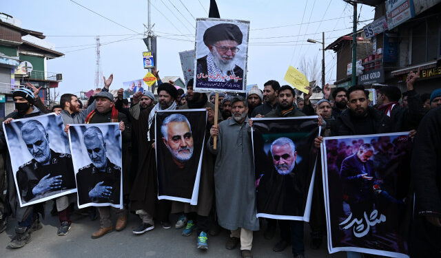 Protesters shout slogans against the United States and Israel as they hold posters with the image of top Iranian commander Qasem Soleimani, who was killed in a US airstrike in Iraq, and Iranian President Hassan Rouhani during a demonstration in the Kashmiri town of Magam on January 3, 2020. - Hundreds of people in Indian Kashmir staged "anti-American" demonstrations in the troubled territory on January 3 within hours of US forces killing a top Iranian commander. (Photo by Tauseef MUSTAFA / AFP)