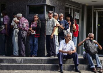 Elderly people wait for their pension monthly payment outside a bank in Caracas, on February 22, 2019. (Photo by RONALDO SCHEMIDT / AFP)
