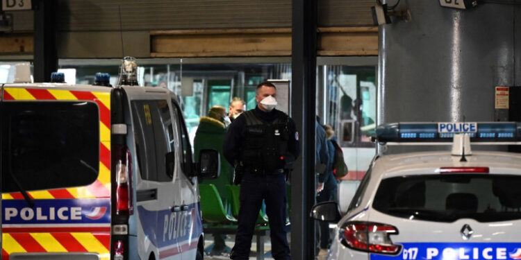 A police officer stands guard at the train and bus station  Lyon Perrache after marking a security zone, following the blockage of a bus coming from Milan due to suspected COVID-19 the novel coronavirus on board, in Lyon, on February 24, 2020. (Photo by JEAN-PHILIPPE KSIAZEK / AFP)