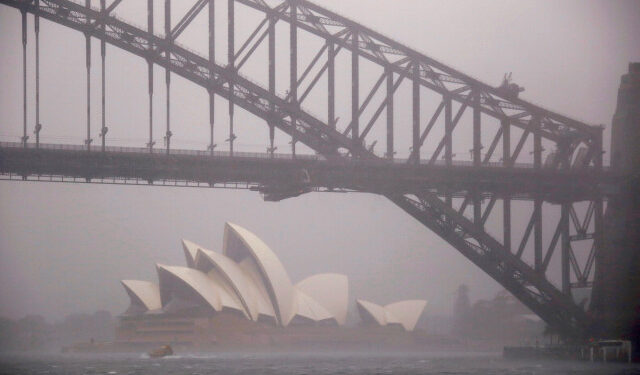 FILE PHOTO: A boat passes under the Sydney Harbour Bridge and in front of the Sydney Opera House as strong winds and heavy rain hit the city of Sydney, Australia, November 28, 2018.    REUTERS/David Gray