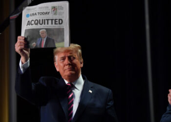 US President Donald Trump holds up a newspaper that displays a headline "Acquitted"  as he arrives to speak at the 68th annual National Prayer Breakfast on February 6, 2020 in Washington,DC. - President Donald Trump said Thursday that he suffered a "terrible ordeal" during his impeachment. In his first public comments since being acquitted by the Senate of abuse of office, he said he had been "put through a terrible ordeal by some very dishonest and corrupt people." "They have done everything possible to destroy us and by so doing very badly hurt our nation," he said at a televised prayer breakfast with a Who's Who of Washington power brokers. (Photo by Nicholas Kamm / AFP)
