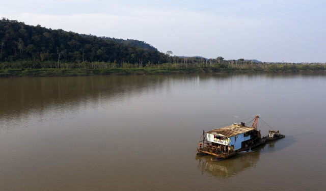 The boat of an illegal gold miner, or "garimpeiro," is seen on a river in the Amazon basin, south of Porto Velho, in the northwestern Brazilian state of Rondonia, on August 27, 2019. (Photo by Carlos FABAL / AFP)