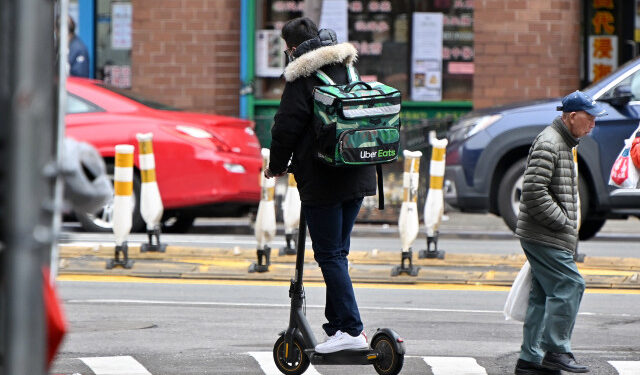 NEW YORK, NEW YORK - MARCH 19: An Uber Eats delivery worker is seen riding an electric scooter in Manhattan's Chinatown on March 19, 2020 in New York City. Schools, businesses and most places where people congregate across the country have been shut down as health officials try to slow the spread of COVID-19.   Dia Dipasupil/Getty Images/AFP