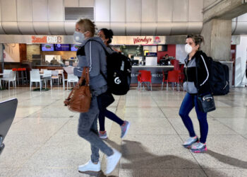 People wear protective masks in response to the spreading of coronavirus (COVID-19), at Simon Bolivar international airport in Maiquetia, Venezuela March 15, 2020. REUTERS/Carlos Jasso