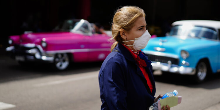 A woman wears a mask as a precaution against the spread of the new coronavirus at the Jose Marti International Airport in Havana, Cuba, Thursday, March 12, 2020, after the government announced its first new virus cases. The vast majority of people recover from the new virus. (AP Photo/Ramon Espinosa)