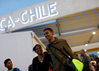 Adrian Naveda, Alejandra Rodriguez and her nephew David Vargas (R-L), traveling by bus from Caracas to Chile, smile after crossing the border between Peru and Chile at the migration office in Arica, Chile, November 13, 2017. Getting to Chile was the goal, but everyone was a little worried, because they knew this was the border where the authorities could ask them tricky questions. As they walked out of the migration office in Arica, happiness and a mood of "We made it!" took over, even though they still had two more days on the road ahead of them. REUTERS/Carlos Garcia Rawlins  SEARCH "RAWLINS BUS" FOR THIS STORY. SEARCH "WIDER IMAGE" FOR ALL STORIES.