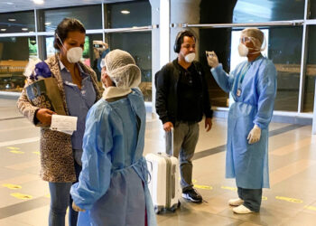 Personal médico del Ministerio de Salud verifica la temperatura de pasajeros a su llegada al aeropuerto internacional El Dorado de Bogotá, Colombia, 15 de marzo, 2020. REUTERS/Luisa González
