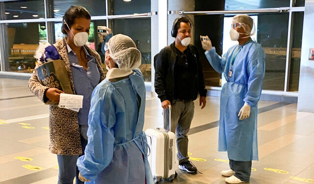 Personal médico del Ministerio de Salud verifica la temperatura de pasajeros a su llegada al aeropuerto internacional El Dorado de Bogotá, Colombia, 15 de marzo, 2020. REUTERS/Luisa González