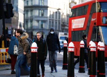 Varias personas, algunas con mascarillas, caminan por Londres mientras el número de casos de coronavirus en todo el mundo sigue creciendo. 16 de marzo de 2020. REUTERS/Henry Nicholls