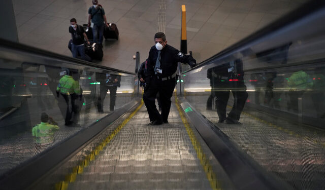A security guard wears a face mask inside El Dorado International Airport after flights were suspended to curb the spread of coronavirus disease (COVID-19), in Bogota, Colombia March 24, 2020. Picture taken March 24, 2020. REUTERS/Nathalia Angarita. NO RESALES. NO ARCHIVES.