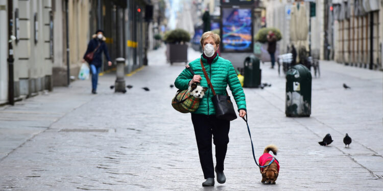 Una mujer pasea a su perro durante el encierro sin precedentes en toda Italia impuesta para frenar el brote de coronavirus, en Turín, Italia, el 15 de marzo de 2020.
Massimo Pinca / Reuters